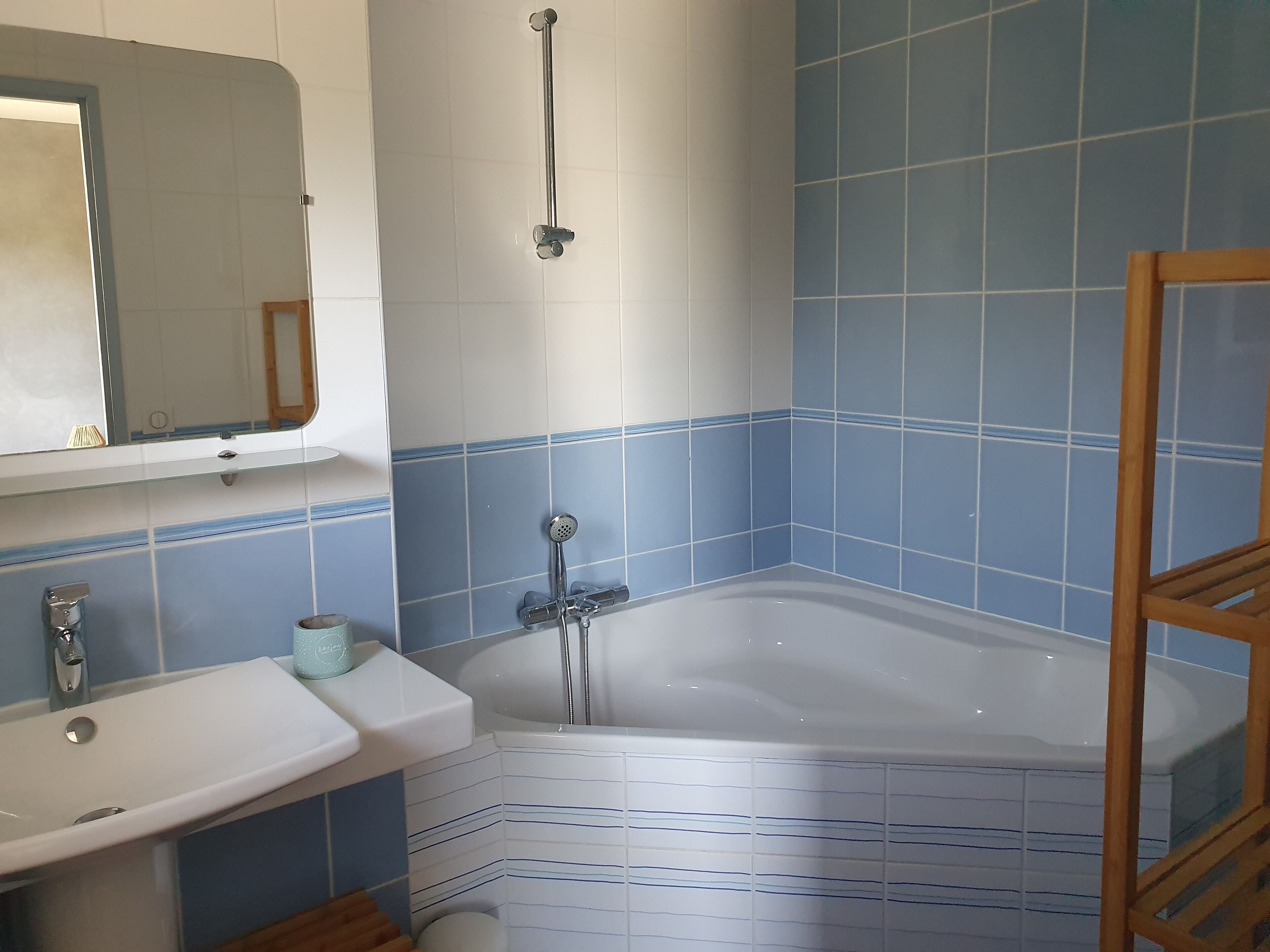 Une salle de bain avec une baignoire, un lavabo et un miroir.
