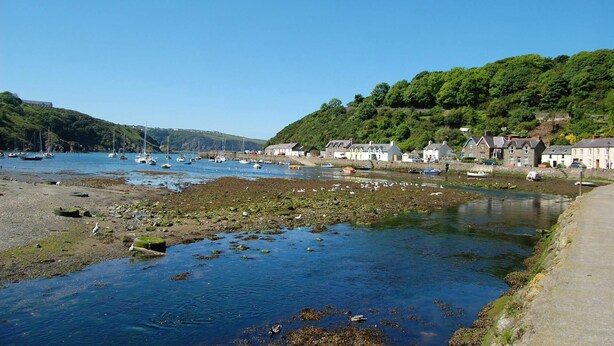 A coastal town with a rocky shoreline, boats, and houses along the water. - Tal y Gaer Cottage, Fishguard (Trefasser)