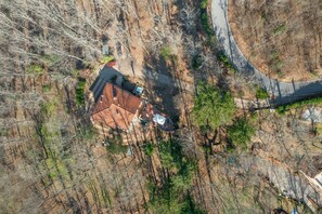 An aerial view of a house with a red roof, surrounded by trees and a curved road. - La Vita Bella in Vaglia (Vaglia)