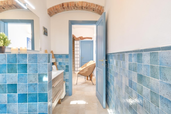 A narrow hallway with blue-tiled walls and a wooden door leading to a room. - La Vita Bella in Vaglia (Vaglia)