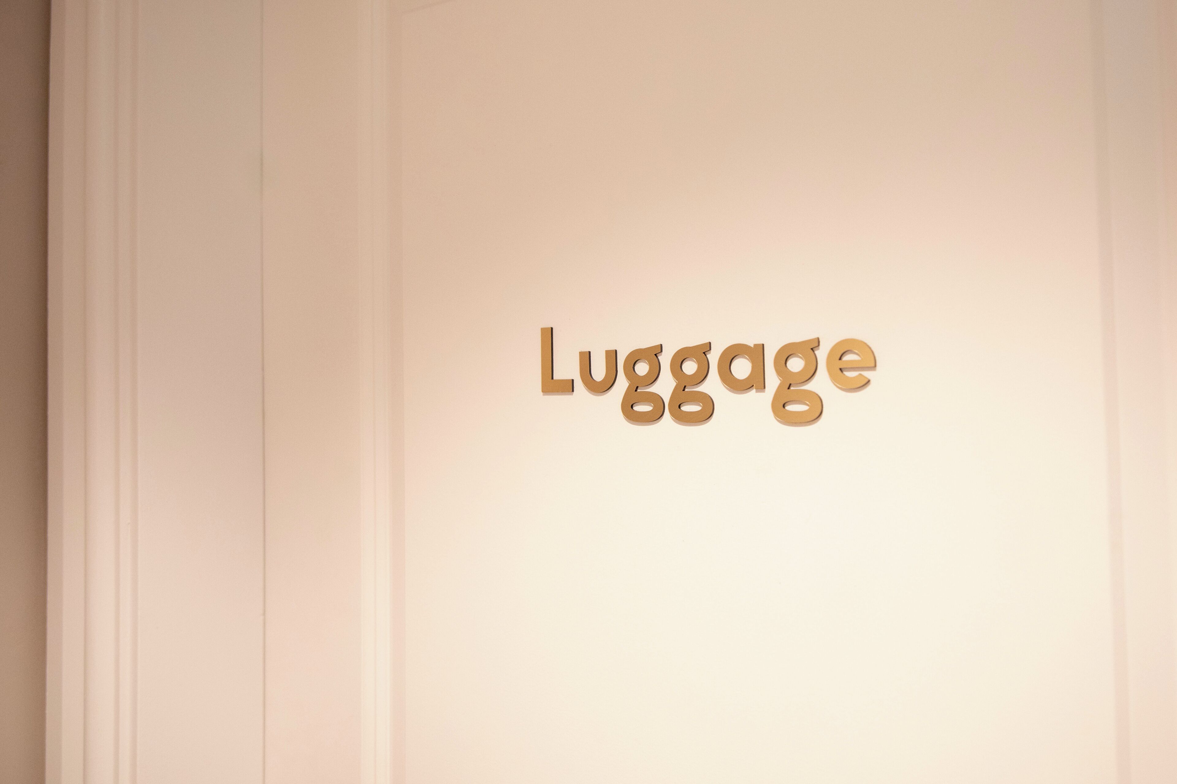 A wall with the word "Luggage" in a stylized font.