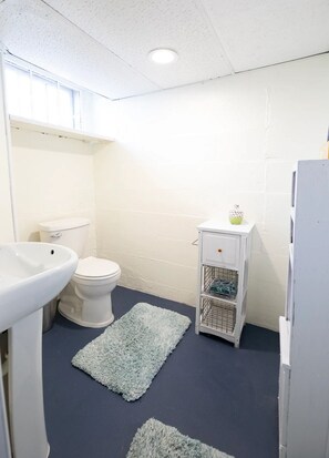 A small bathroom with a toilet, sink, and a small cabinet with a decorative item. - The Sunflower Home- Game Room & Hot Tub! Pet Friendly: Dogs & Cats are welcome! (Superior)