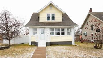 A single-story house with a gabled roof, a front porch, and a visible front door.