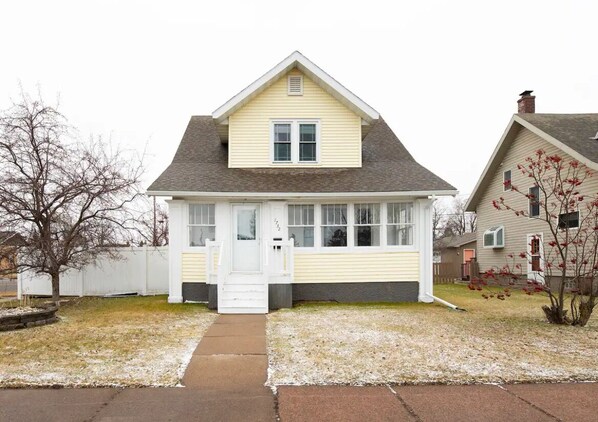 A single-story house with a gabled roof, a front porch, and a visible front door. - The Sunflower Home- Game Room & Hot Tub! Pet Friendly: Dogs & Cats are welcome! (Superior)