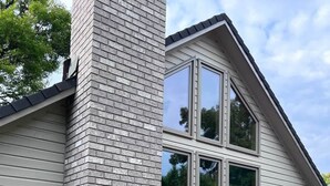 A modern house with a brick chimney, large windows, and a door. - Charming Italian Villa Retreat • 10 Min to UO & Autzen (Eugene)
