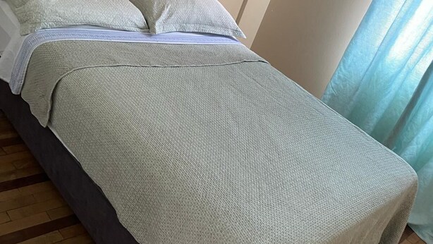 A bed with a grey blanket and pillows, a dark-colored headboard, and a wooden floor. - Full apartment in Barranco, close to the main park lovely space (Barranco)