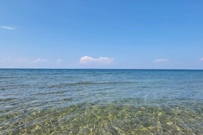 Una playa con aguas poco profundas y un mar tranquilo.