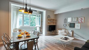 Ein modernes Wohnzimmer mit Essbereich, Holzboden und Kamin.