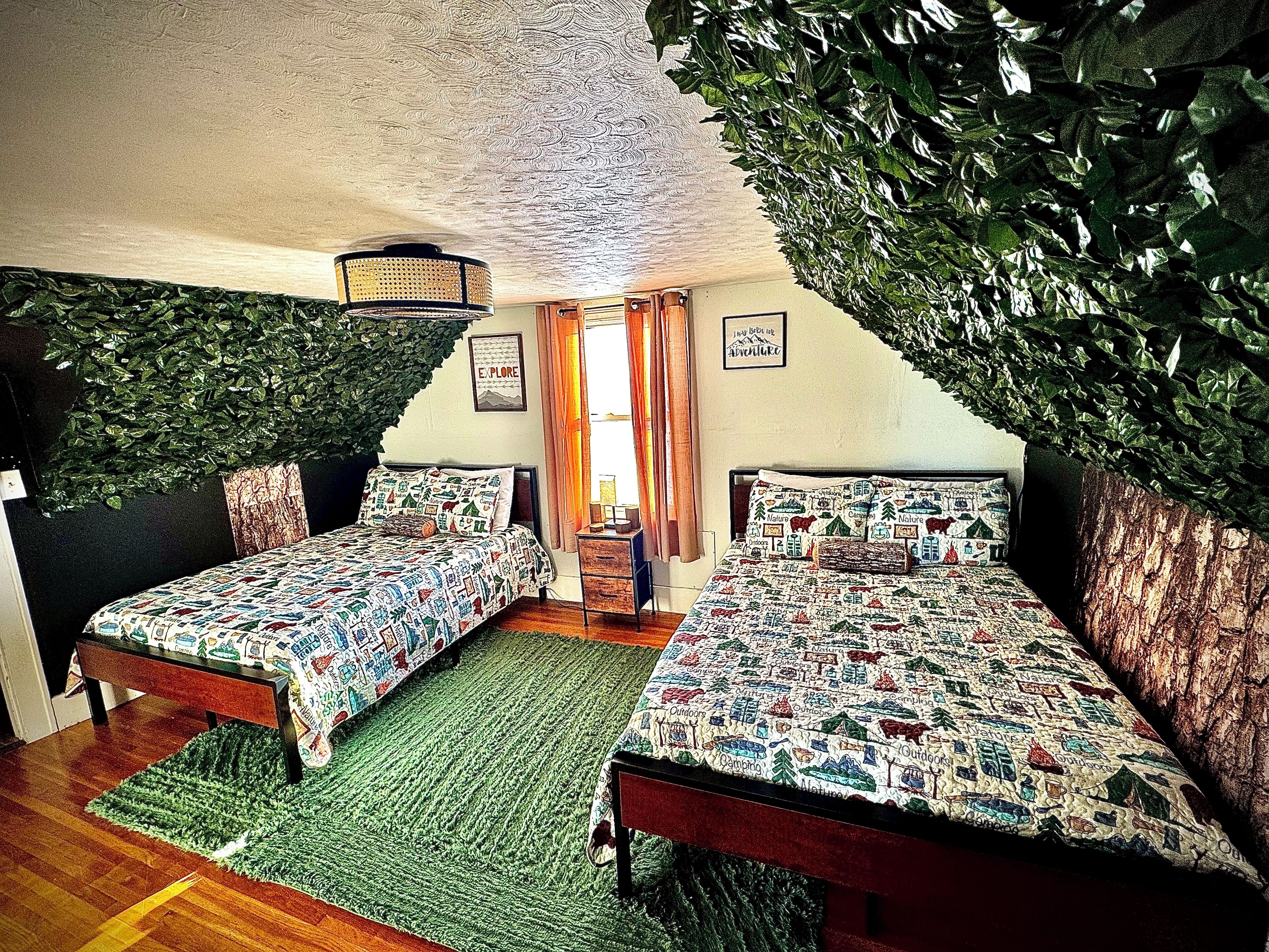 A bedroom with two beds, a green rug, and a ceiling with a leaf-like design.