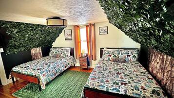 A bedroom with two beds, a green rug, and a ceiling with a leaf-like design.