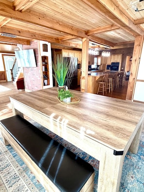 Een houten interieur met een centraal eiland, een bank en een potplant.