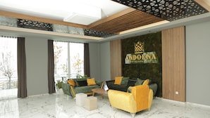 A modern hotel lobby with a large sofa set, a coffee table, and a marble floor. - Andoena Resort (Lipjan)