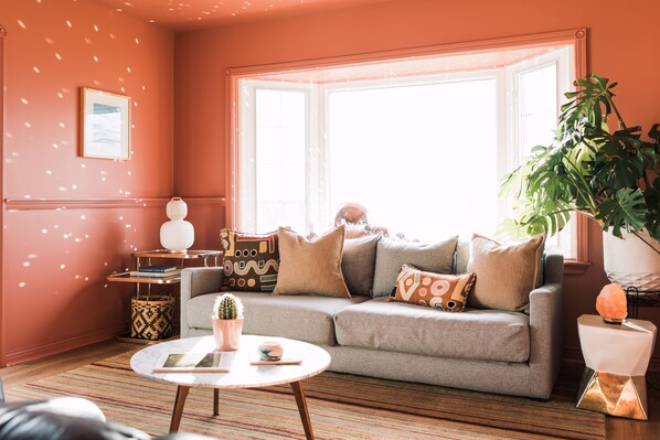 Relax in this inviting living room with a comfortable sofa, round table, and lush greenery.