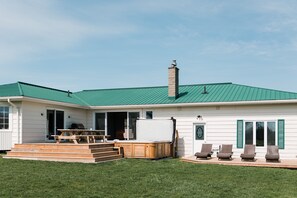 Enjoy a relaxing stay in this charming house with a front porch featuring a hot tub and comfortable seating.