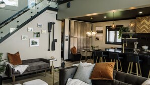 Un espace de vie moderne comprenant un escalier, un coin repas et une cuisine.
