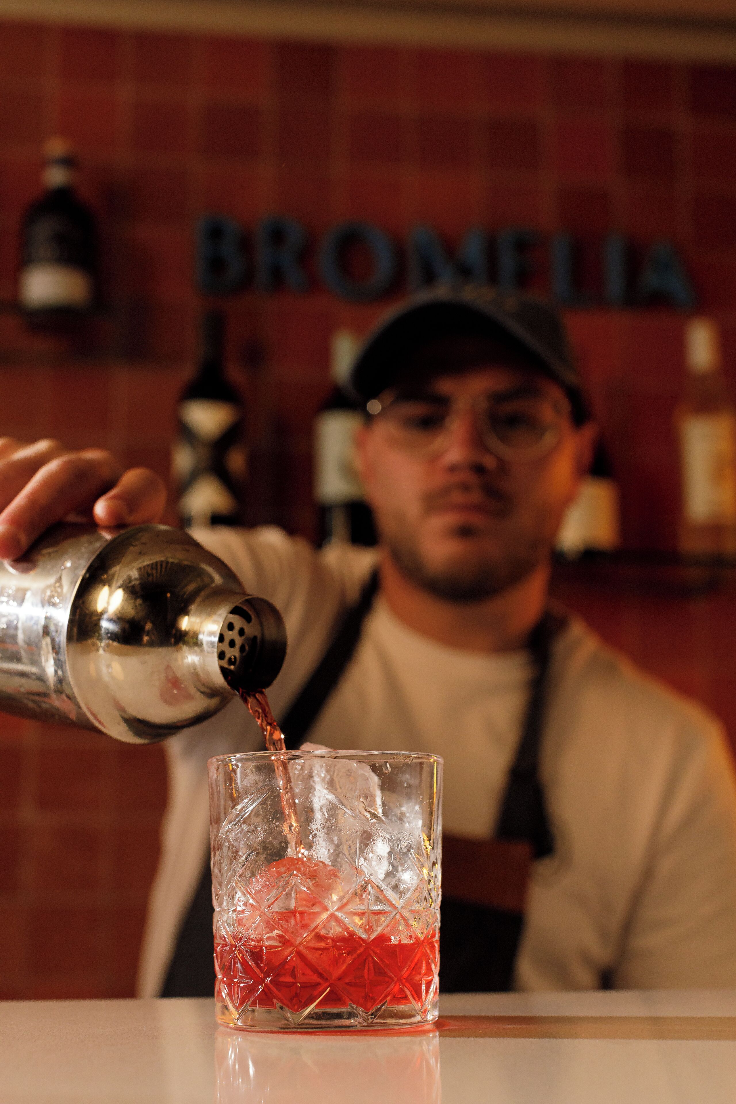 A person pouring a drink into a glass.