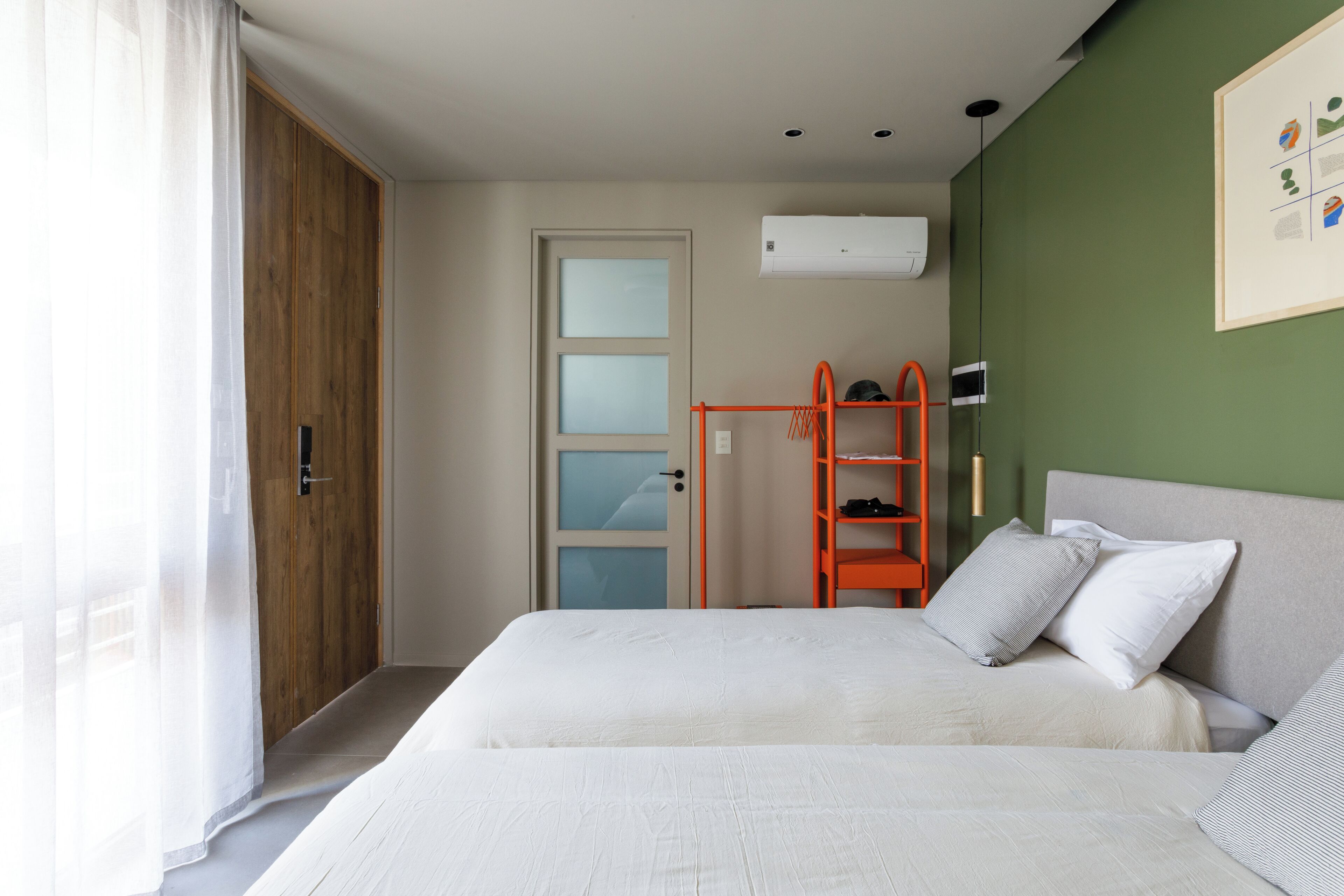 A bedroom with a bed, a wardrobe, a door, and a shelf unit.