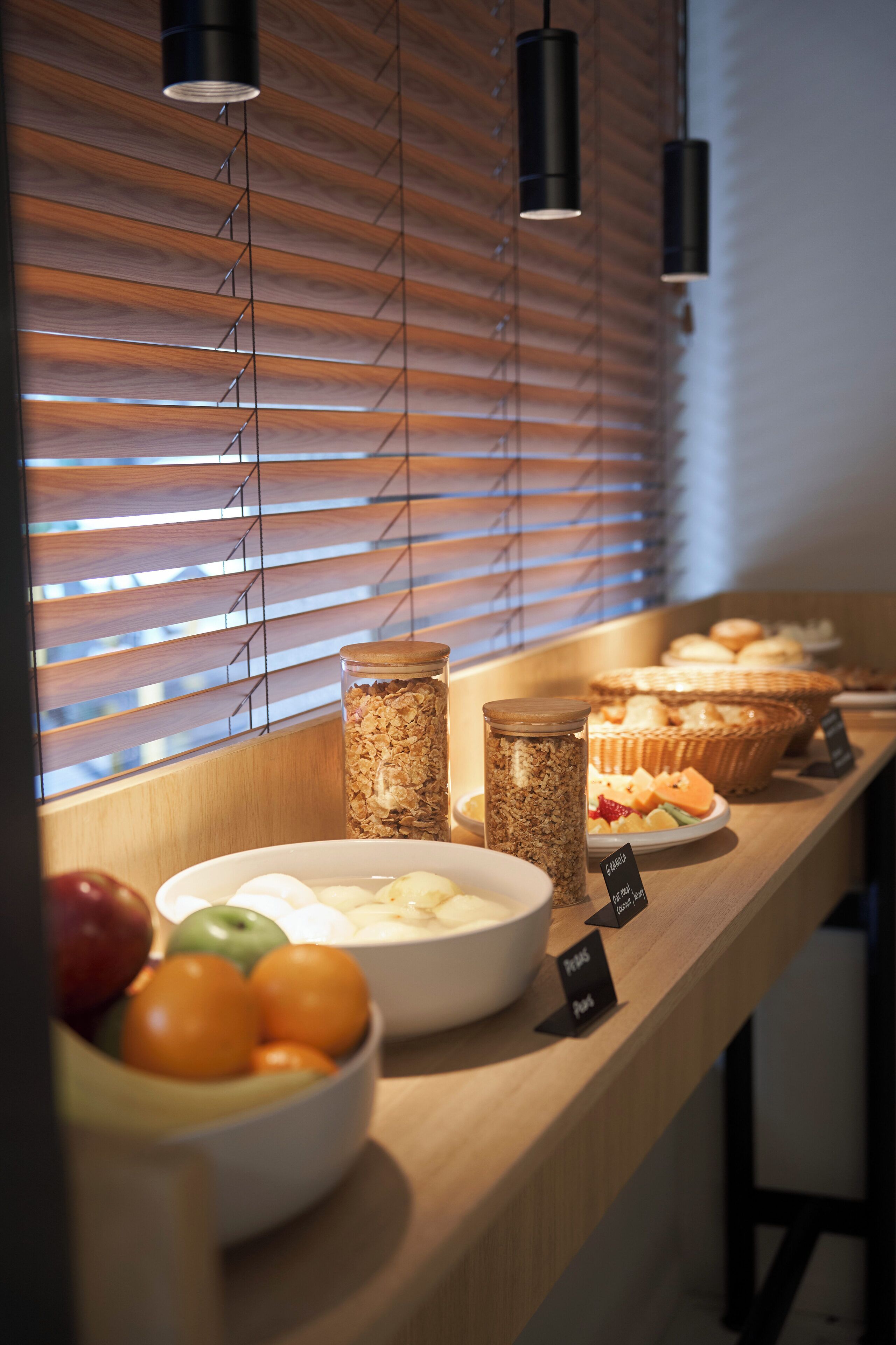 Un bufé de desayuno con diversas opciones de comida y un bol de fruta.