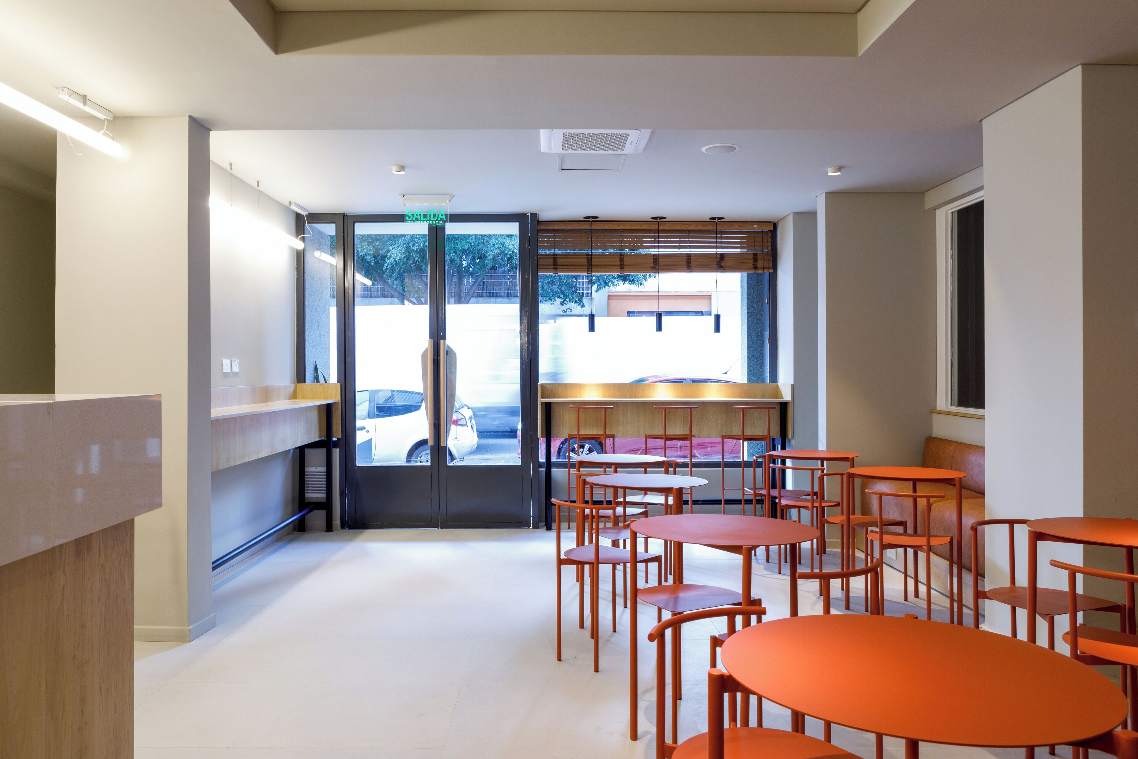 Een modern interieur met een receptiebalie, een zithoek en uitzicht op buiten.