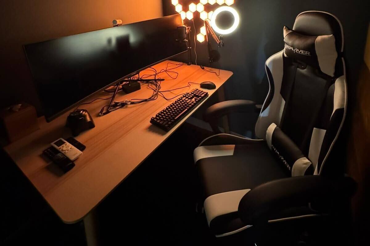 Een gaming stoel, een bureau met toetsenbord en muis, en een beeldscherm.