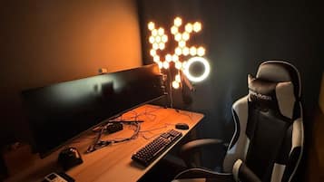 A gaming chair, a desk with a keyboard and mouse, and a monitor.