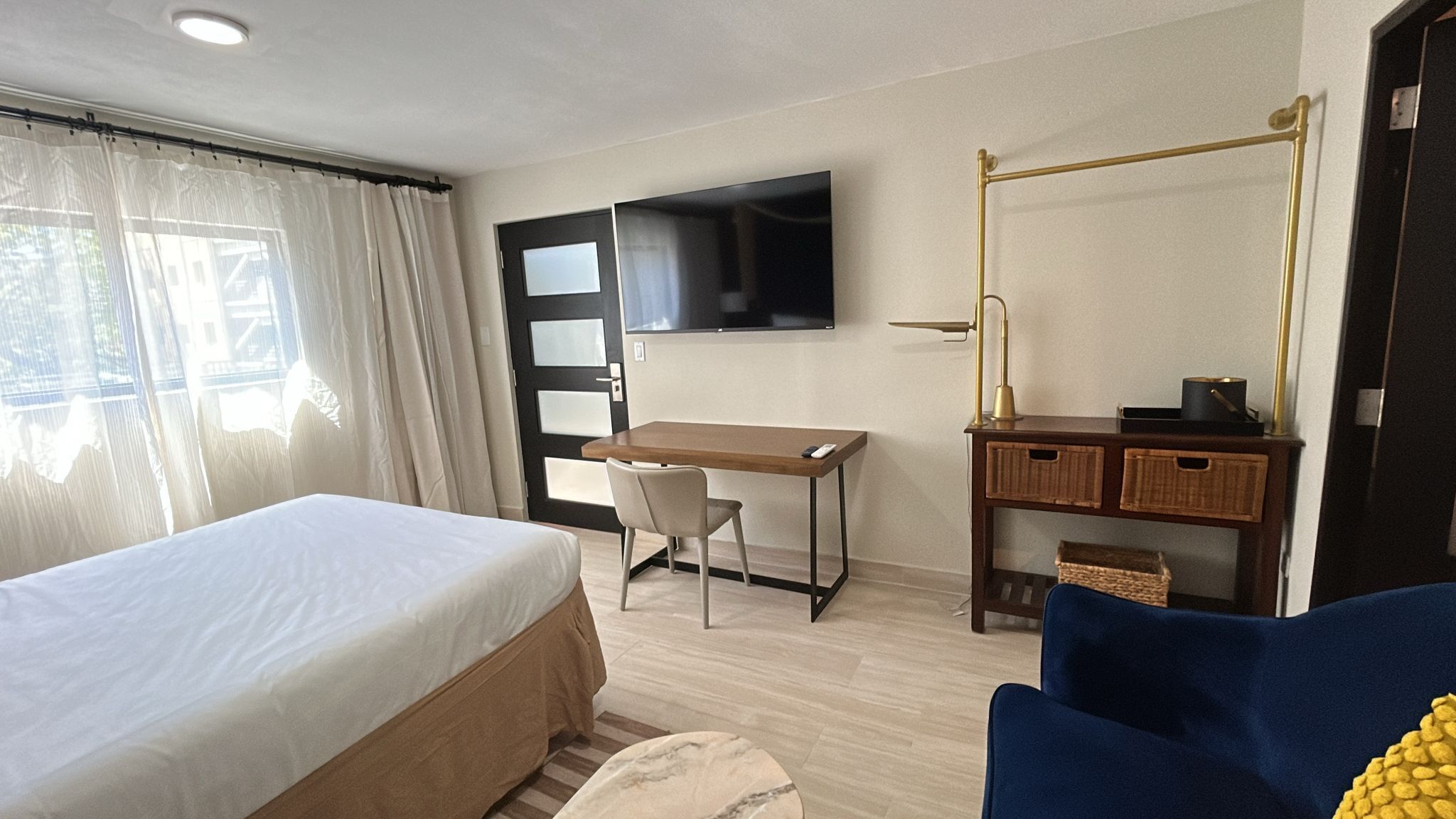 Une chambre d’hôtel équipée d’un lit, d’un bureau, d’une chaise, d’une télévision et d’une armoire.
