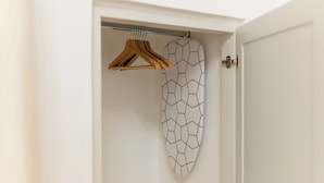 A white door with a geometric-patterned towel hanging on a metal rod.