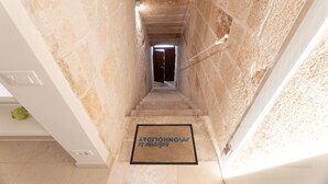 A narrow stairway leading to a door with a doormat reading 'WELCOME TO MONCHOWDAY.'