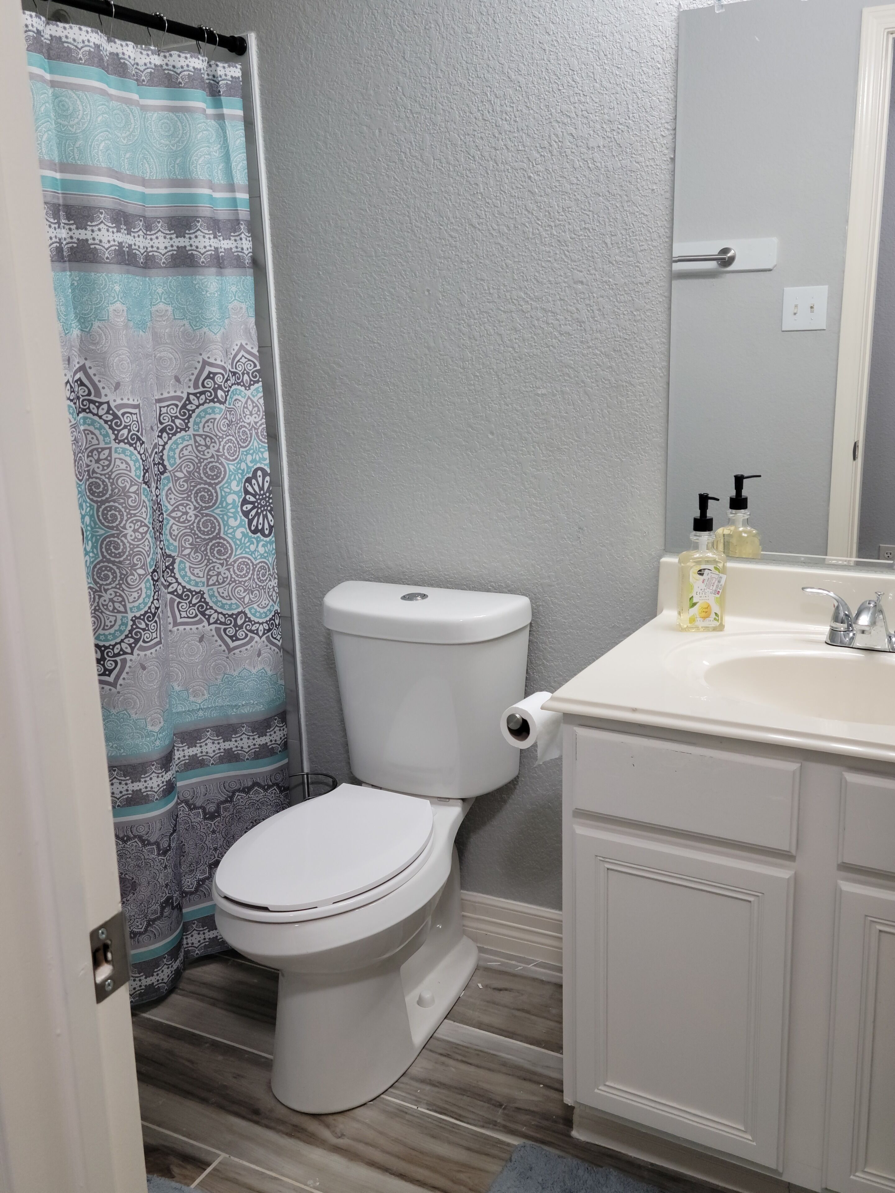 A bathroom with a toilet, a sink, and a shower curtain.
