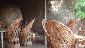 Mobiliario de mimbre bajo una estructura de techo de paja.