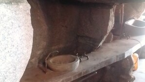 Interior de piedra con un estante rústico y un lavabo.