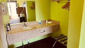 A bathroom with a granite countertop, two sinks, a towel rack, and a mirror.