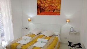 A hotel room with a bed, two bedside tables, a painting, and a chair. - Il Focolare  (Fiumicino)