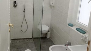 A modern bathroom with a glass-enclosed shower, a toilet, and a sink. - Il Focolare  (Fiumicino)
