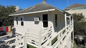 A white single-story house with a porch, a chimney, and a small attached garage. - Comfy Hideaway: Walk to Restaurants and Nightlife (Houston)