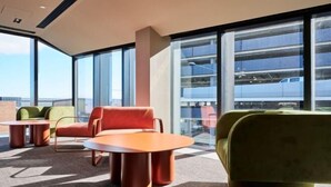 Een moderne zithoek met een bank, stoelen en een kleine tafel.