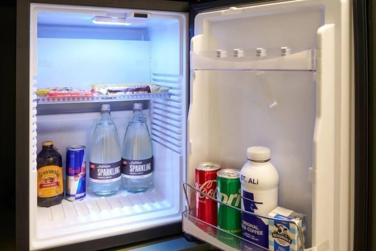 Un réfrigérateur ouvert contenant diverses boissons et un carton de lait.