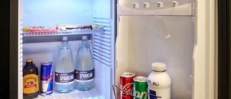 An open refrigerator with various beverages and a milk carton.