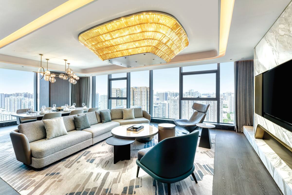 A modern living room with a large sofa, a coffee table, and a TV.