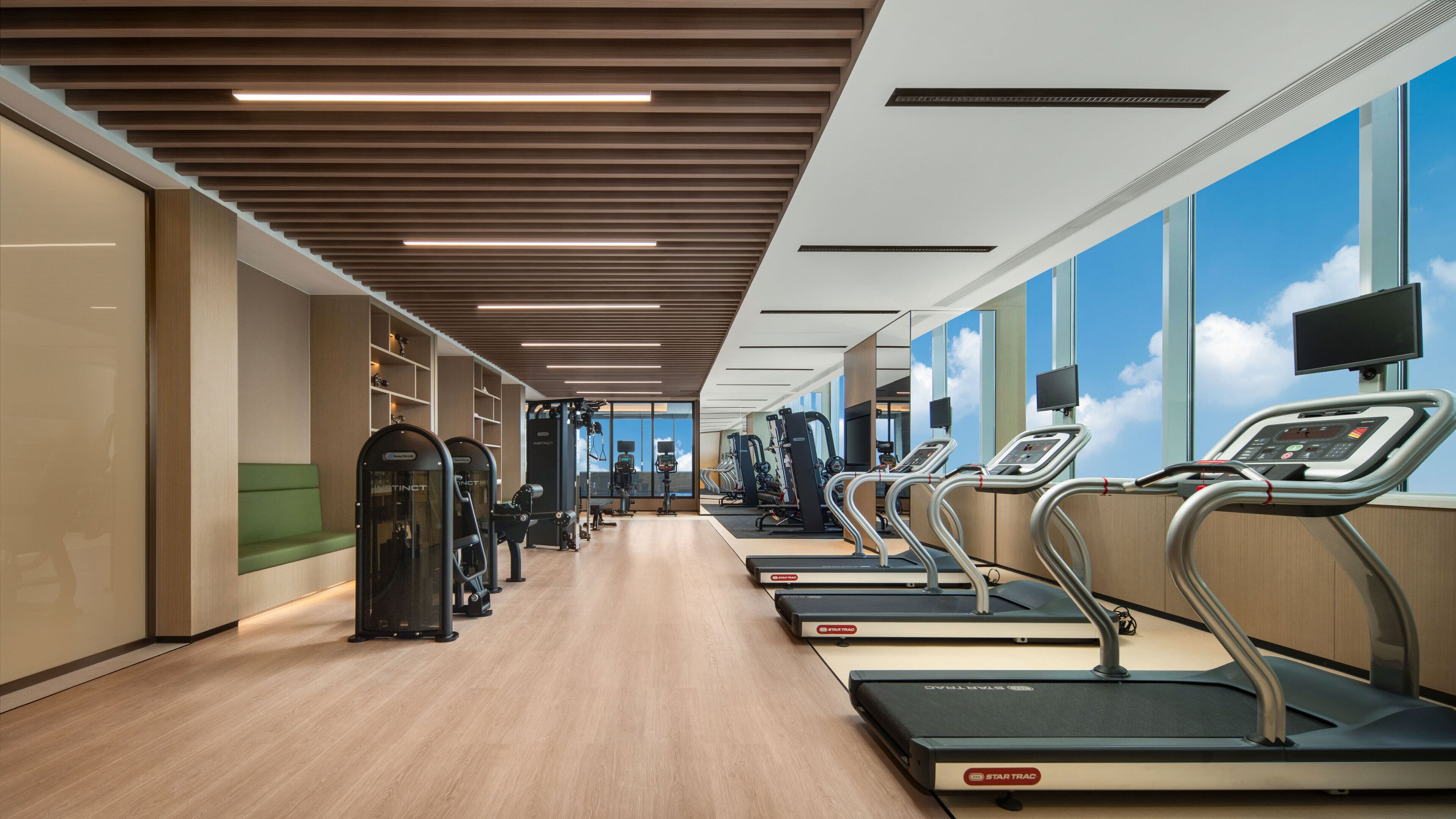 A modern gym with treadmills, weight machines, and exercise equipment.