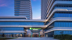 Moderni hotelli, jossa on lasijulkisivu, huomiota herättävä sisäänkäynti ja kyltti, josta ilmenee, että kyseessä on Holiday Inn -hotelli.