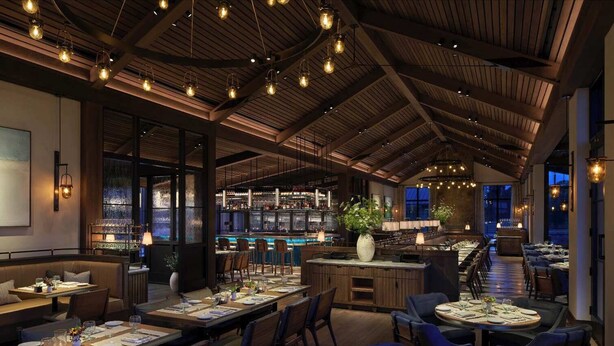 Un restaurante con vigas de madera, lámparas colgantes y una zona de bar.