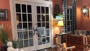 Una habitación acogedora con una mesa de madera, un banco, un aparador decorativo y un amplio ventanal de arco.