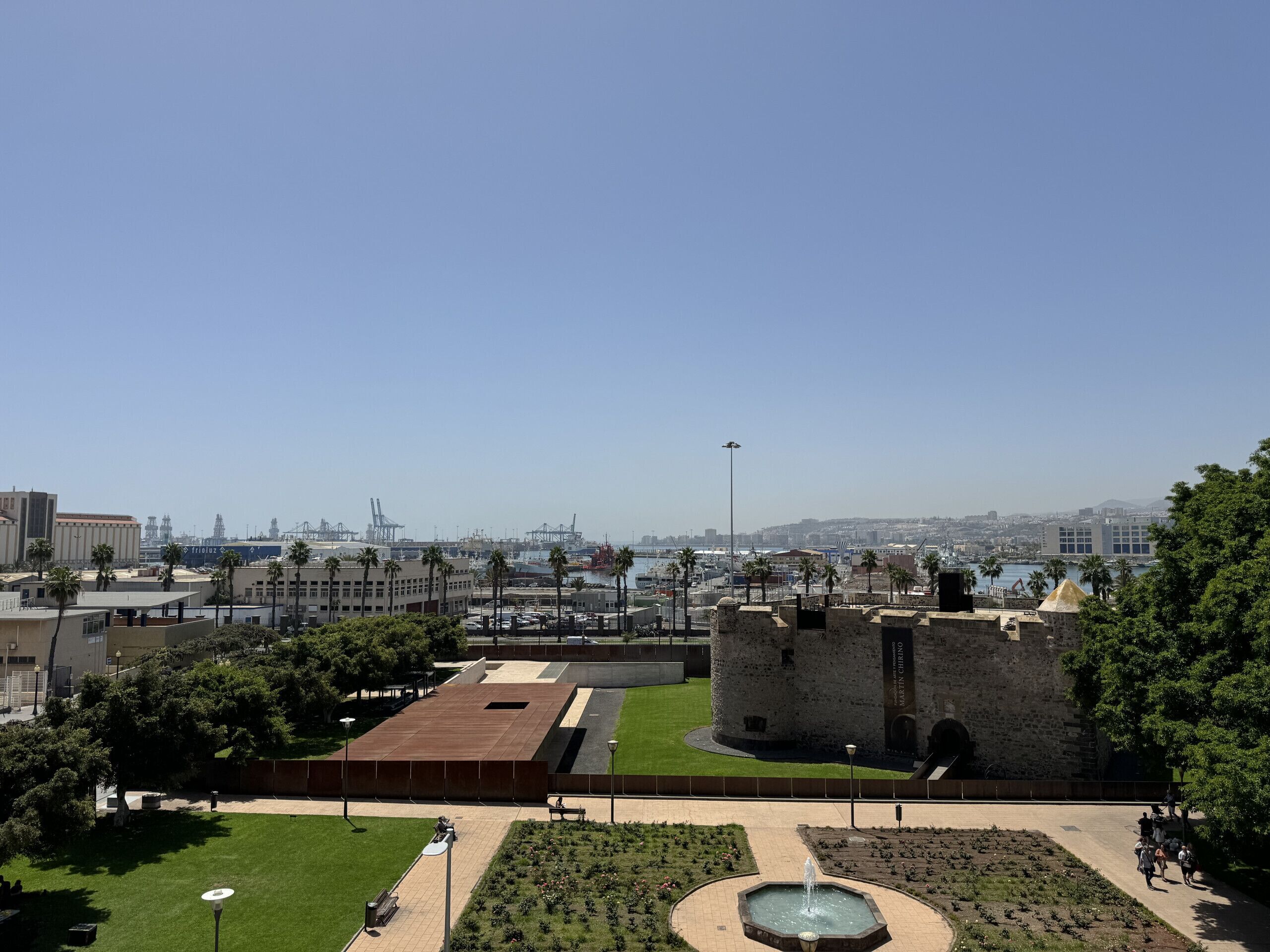 Un’antica fortezza con un fossato, un edificio moderno e uno yacht club sullo sfondo.
