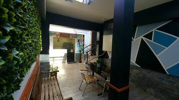 A modern interior with a wooden bench, a staircase, and a wall with geometric patterns.