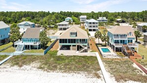 A beachfront property with multiple houses, a swimming pool, and a staircase leading to a deck. - Farr Away Living (Port St. Joe)
