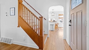 A staircase with wooden railings leading to a kitchen area with white cabinets and a stainless steel sink. - Lux 4br 3ba, hot tub, stargazing, HUGE gameroom, 10 min to Summersville Lake (Summersville)