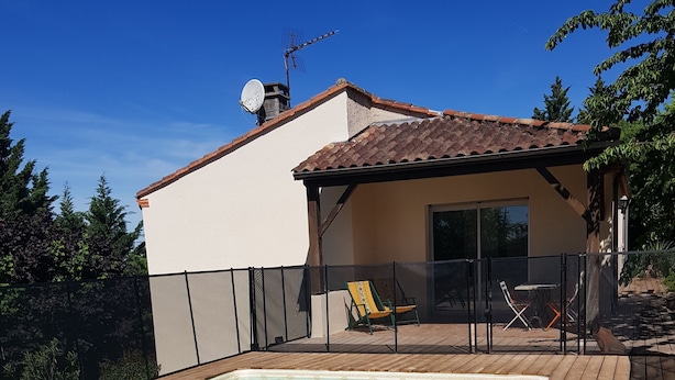 A swimming pool with a wooden deck, a covered patio area, and a satellite dish on the roof. - Villa Pech DE Durand Villeneuve SUR LOT Acces PMR (Villeneuve-sur-Lot)