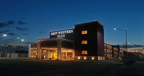Een hotel genaamd 'Best Western Plus' met een modern design, een opvallende entree en een goed verlichte gevel.
