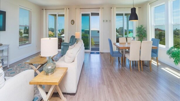 Un grand espace de vie comprenant un canapé, une table à manger, des chaises et un téléviseur.